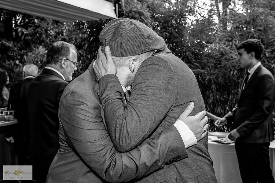 Abrazo emotivo durante el coctel en el jardín de una boda en Madrid