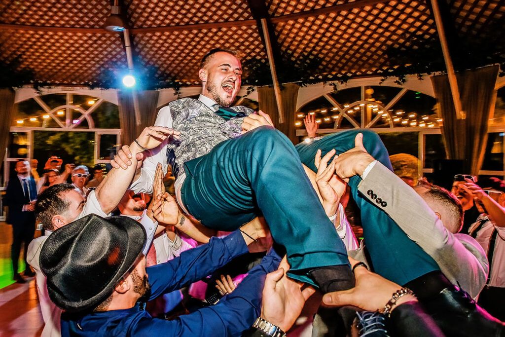 Foto de fiesta de boda con manteo al novio. Realizada por Chema & Davinci